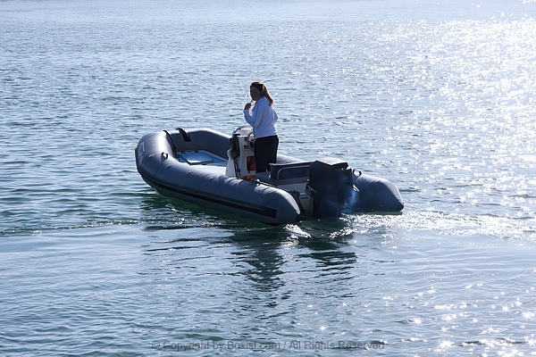 Woman On Inflatable Boat In Open Sea Water