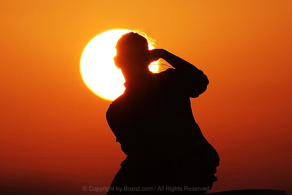 Dramatic Silhouette Of Woman Watching Sunset With Giant Sun Behind Her