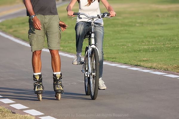 Cyclist And Rollerblader Partner Strolling Street