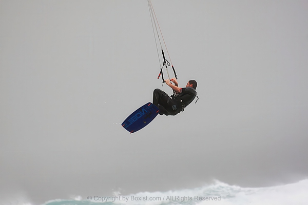 Kitesurfer On Board Jumping High Over Ocean Waves