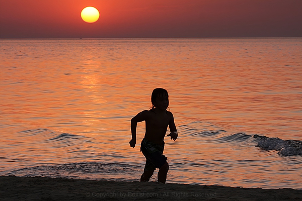 Boy Running On The Beach At Sunset