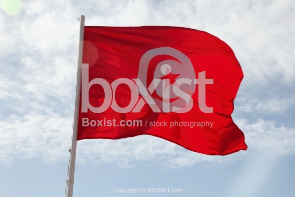 Tunisian Flag Waving Against Blue Sky