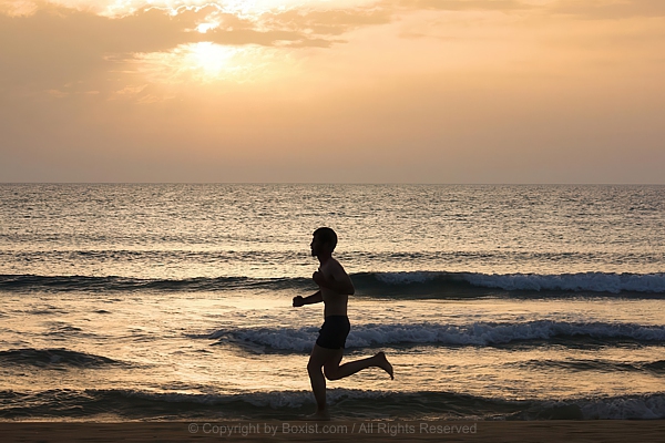 Athlete Sprinting Along Shoreline During Sunset