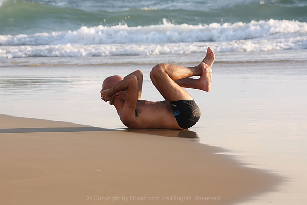 Athletic Man Training Abs Workout On Sunny Beach Sand 