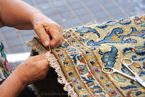 Skilled Elderly Artisan Hands Repairing Oriental Carpet Fringe