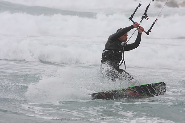 Kiteboarder Carving Through The Waves