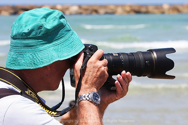 Photographer Capturing Seascape With Blurry Ocean Background