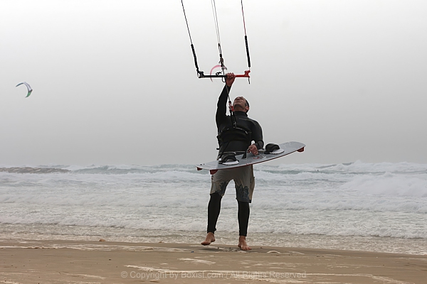 Energetic Kite Surfer Preparing Gear On Sandy Shore