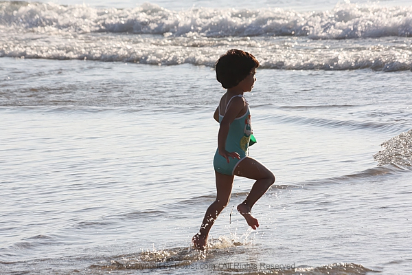 Little Girl Running To Play In Sea Waves