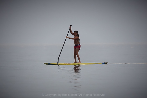 Girl Paddle Boarding On Calm Water