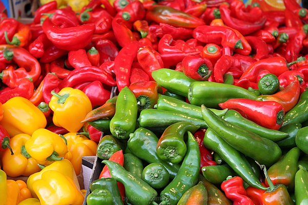 Vibrant Pile Of Fresh Peppers Displayed In A Market Setting
