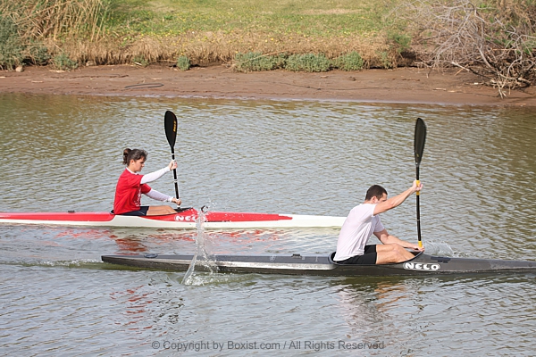 Two Adventurers Paddle Their Kayaks Along Scenic River Journey