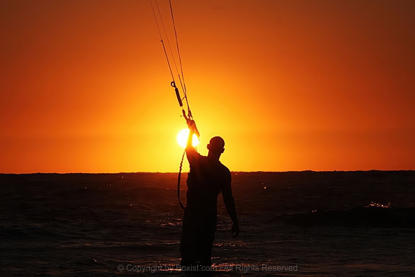Kite Surfer Silhouetted Against Fiery Sunset Horizon
