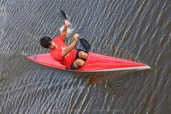 Solo Kayaker Paddles His Red Kayak On Calm Waters