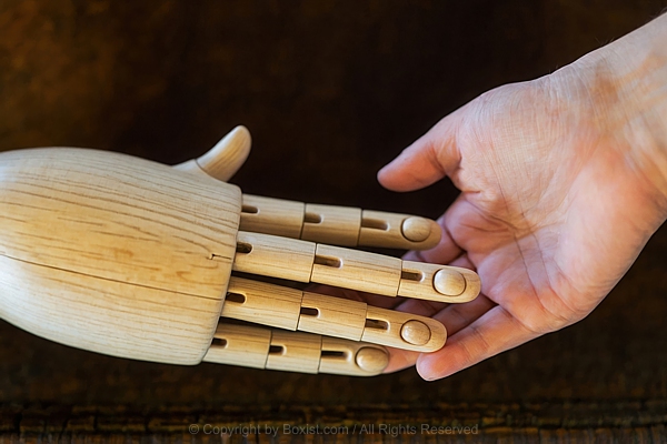 Human Hand Touching Wooden Mannequin Hand