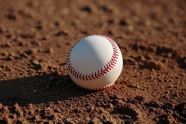 Baseball Resting On The Dirt Ground Of A Baseball Field