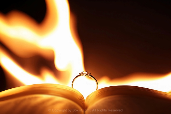 Open Book With A Golden Ring Standing Upright On Its Pages With Warm Flame Background