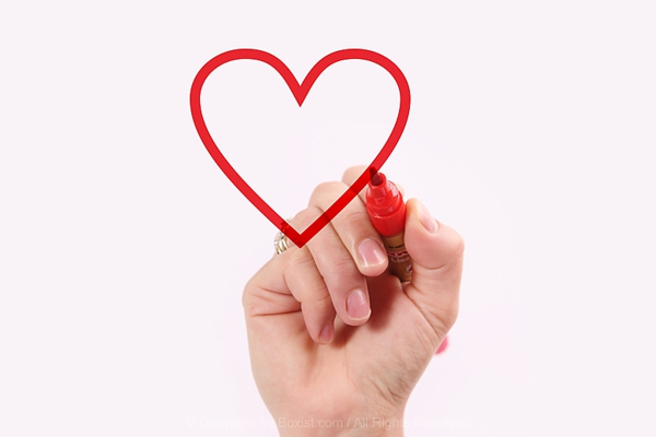 Hand Holding Red Marker Drawing Love Heart On Bright Background