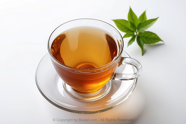 Clear Glass Teacup With Mint Green Leaves On White Surface