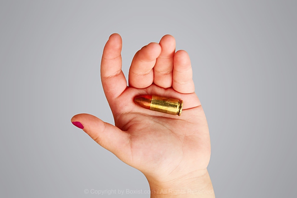 Little Girl Hand Holding A Bullet