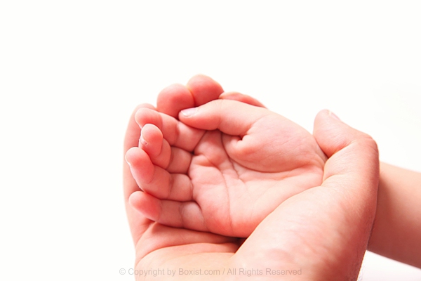 Father Hand Cradles Baby Hand