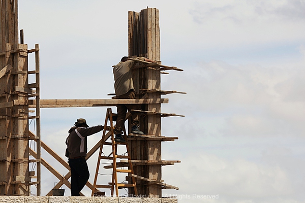 Construction Workers On Wooden Scaffolding
