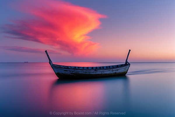 Long Exposure Photograph Of Lone Old Boat On Calm Sea Under Dramatic Colorful Sky