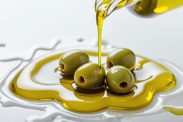 Green Olives Sitting In Puddle Of Olive Oil With Stream Of Olive Oil Pours Down