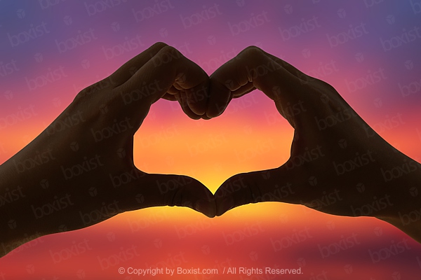 Hands forming a heart shape with sunset silhouette. Hand shaped heart in  the sky. Stock Photo